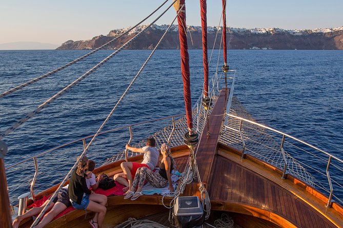 Santorini Caldera Sunset Sailing Cruise with Dinner and Wine - Stop 4: sunset near Oia from the water, with a glass of wine