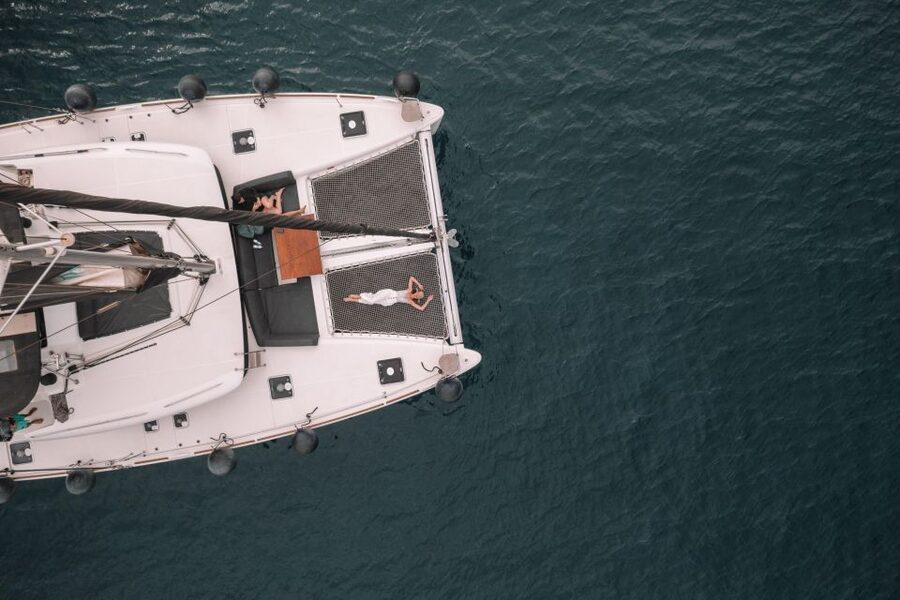 Santorini Catamaran Cruise with Swimming, Meal and Open Bar - Sailing past White Beach and Akrotiri Lighthouse, views without the hike