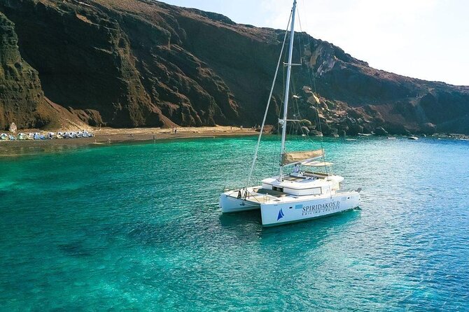 Santorini Private Catamaran Cruise with BBQ, Open Bar & Transfers - Indian Rocks, Fira and Imerovigli from sea level, and the lighthouse pass